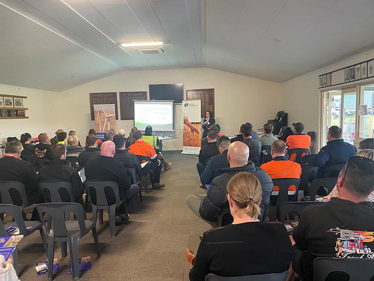 Photo of person presenting to a seated audience of people.