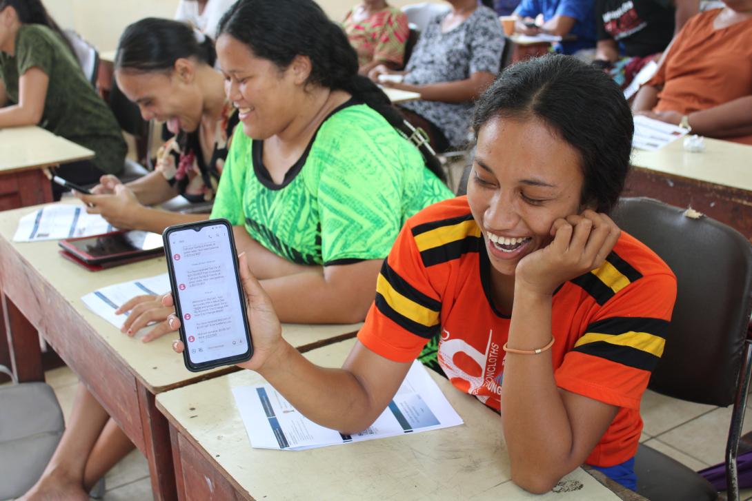 Smiling woman showing the contents of her mobile phone to the camera.