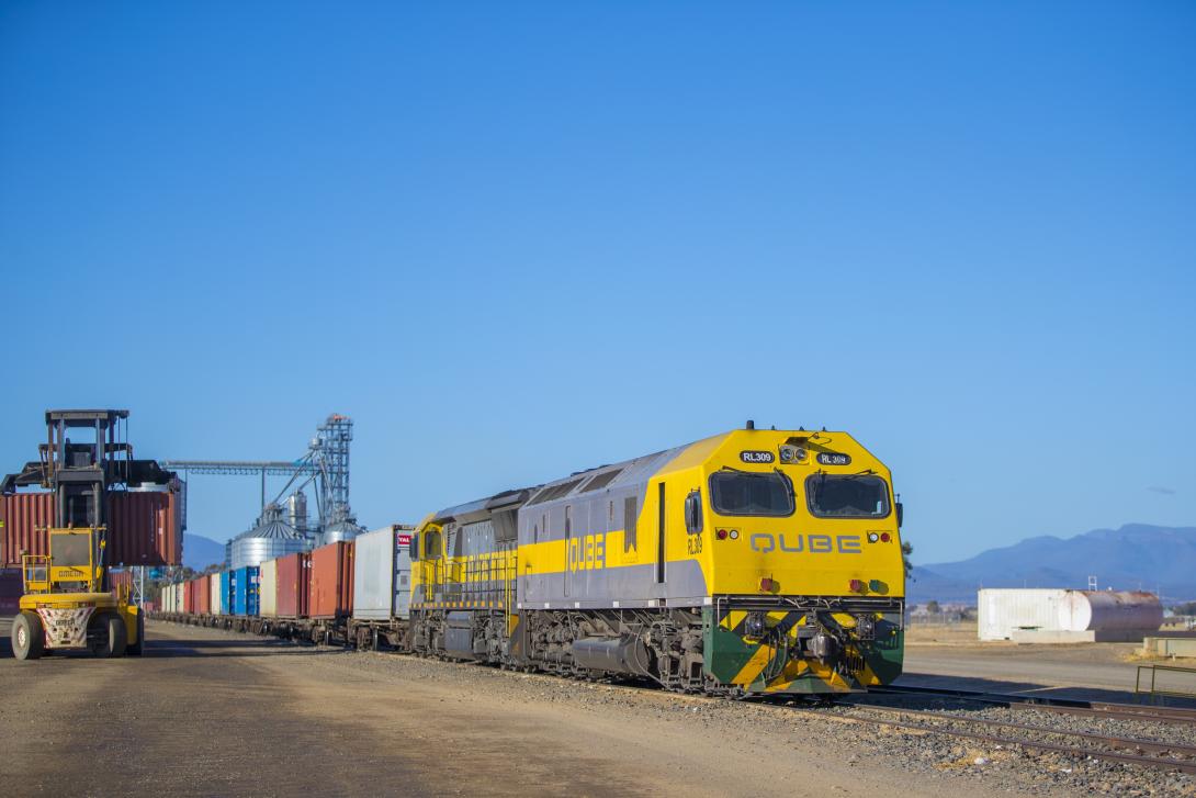 Freight train being loaded with containerised cargo.